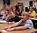 Kids answer math questions at their desks