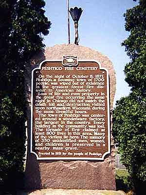 
The state historical marker, erected at the Peshtigo Fire Cemetery in 1951, includes a torch for a perpetual flame.
 (Photo by Deana Hipke, copyright 2000)