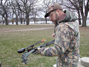 
Kent Rydberg grew up hunting in Iowa, but lives now near Dassel, Minn. He checks his compound bow before heading across a plowed field for the first part of the hunt. (MPR Photo/Jeff Horwich)