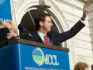 
 Following speeches by state officials and U.S. House members, Gov.
Pawlenty (shown) and Lt. Gov. Carol Molnau took the podium and waved
greetings, despite calls of "speech" in the crowd. (MPR Photo/Tom Scheck)