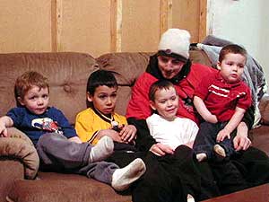 
Michelle's brother and his son watch TV with Adrian, Eric, and Agnelo Romero.
 (MPR Photo/Stephanie Hemphill)