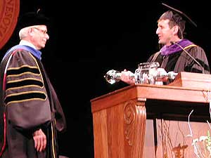
Bruininks accepts the traditional mace from Gov. Pawlenty. The mace, first used in 1961 for the inauguration of O. Meredith Wilson, has an aluminum handle and a "hammer" made of crystal. It is a symbol of authority. (MPR Photo/Marisa Helms)