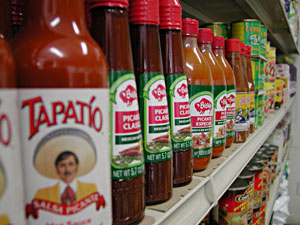 
Colorful bottles and spices brighten up a corner of the market.  Abraira found a distributor by calling the phone numbers on the back of the food in his own pantry. (MPR Photo/Jeff Horwich)