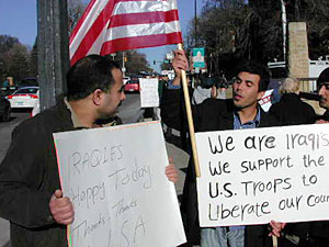 
Toward the end of the vigil, Aljaffery and Rahim Al Shamary appeared on the bridge with signs thanking the U.S. for liberating their country. (MPR Photo/Marisa Helms)