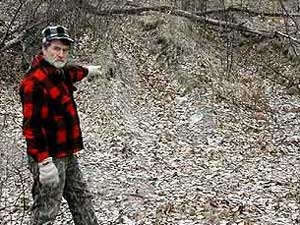 
A local resident stands below an unauthorized ATV trail, in Spider Lake, which has caused erosion on the hillside. The DNR sometimes attempts to block the trails with logs or rocks, but it does little to prevent new trails nearby. 
 (MPR file photo)