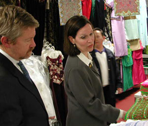 
U.S Ambassador to Laos Douglas Hartwick and U.S. Representative Betty McCollum look at Laotian fabrics at Sunrise Market in St. Paul (MPR Photo/Art Hughes)