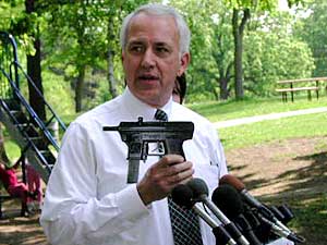 
Sen. Wes Skoglund, DFL-Minneapolis, holds a cardboard cutout of a handgun as he begins a petition drive to repeal the new conceal and carry law. (MPR Photo/Art Hughes)