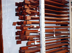 
Wehling uses wood from Brazil for the stick of the bow.  It's extremely dense and prized for its red coloring.  He stacks roughly cut sticks in their initial stages until the time comes to transform them into bows. (MPR Photo/Erin Galbally)