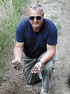 
Retired DNR enforcement officer Roger Leuth sits below an all-terrain vehicle trail in a ditch near his home. Leuth says the trail is causing erosion into a nearby wetland. (MPR Photo/Tom Robertson)