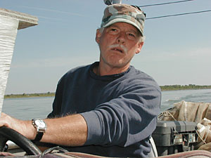 
River ecologist Larry Hesse pilots his boat on the Missouri River.  He's studied the river for 30 years. (MPR Photo/Mark Steil)