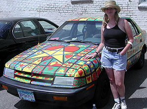 
Cat Corrigan teaches in the St. Paul schools. She painted a grid on her car and then had her students fill in the squares. She says she's seen a lot of good artcars, and some bad. "A good art car -- there's a point to it, a theme. Everything is connected and it's coherent, it works together." (MPR Photo/Euan Kerr)