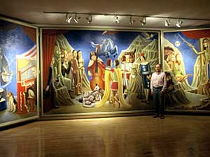 
Artist John Snyder stands before his tryptich painting, "Circus of the Night," which measures nine feet high and 24 feet long.
 (Image courtesy of Weinstein Gallery)