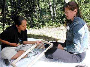 
Veronica Passfield, right, shows Corrie Harper how to do beadwork on a loom. Passfield is from the Bay Mills Indian Community in Michigan's Upper Penninsula. Passfield says Ojibwe language in her community is hanging on by a thread. (MPR photo/Tom Robertson)