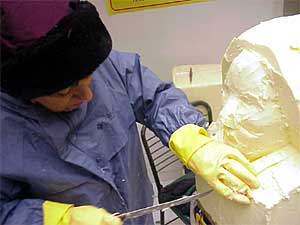 
Linda Christensen wears rain gear to protect her clothes from grease, and rubber gloves to keep her hands warm.  
 (MPR Photo/Steve Nelson)