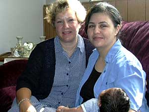 
Aveena Binave, right, a new mother, says her children are healthier because of regular visits from public health nurse Linda Andvik, left. (MPR photo/Dan Gunderson)