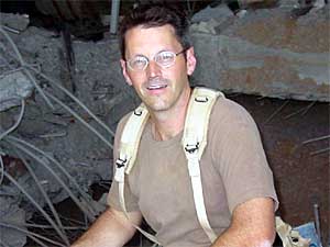 
Maj. Gene Delaune in front of a crater at Baghdad International Airport. The crater is what's left of a palace at the airport. (Photo/Senior Airman Justin Boyd)
