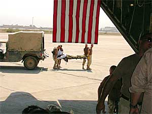 
Maj. Sam Sapio, Master Sgt. Peppy Smith, Master Sgt. Bob Phillips and Senior Airman John Stewart prepare to load a patient into an awaiting aircraft bound for Kuwait. (Photo/Maj. Gene Delaune)