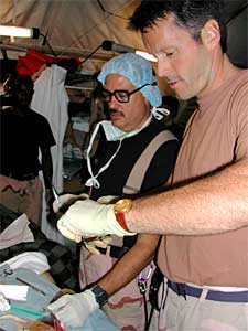 
Maj. Gene Delaune (front) inserts a chest tube into a United Nations patient who was a victim of the U.N. headquarters bombing August 19, 2003. (Photo/Senior Airman Justin Boyd)