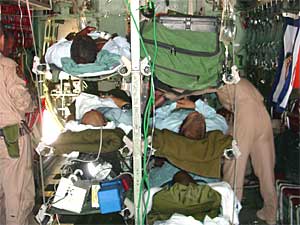 
Patients lying on litters are loaded into stanchions inside a C-130 transport plane, for their flight from Baghdad to a hospital outside the country.  (Photo/Maj. Gene Delaune)