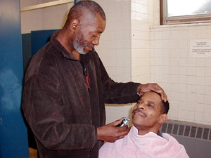 
Barber James Clark gives a free haircut to Listening House guest Gregory Smith. (MPR Photo/Lorna Benson)