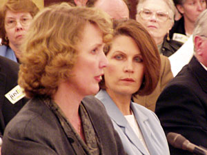 
St. Thomas College of Law professor Theresa Collette says public officials in other parts of the country have started issued marriage licenses to gay couples. At right is Sen. Michele Bachmann. (MPR Photo/Tom Scheck)