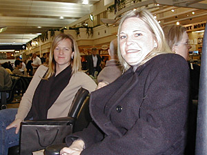 
Jennifer Sharp, left, and Cindy Sanders are waiting to return to Atlanta from a business trip.  Sanders says she does not care how her travel information is used. Sharp says to her, transparency is important. (MPR Photo/Jeff Horwich)