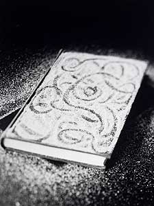 
Photographer James Henkel says he was afraid to harm books when he first started working with them. Everything he did to the book for the photograph could be undone, as in this photograph, "Sand Cover." But now he submerges books in water and even cuts them apart with a bandsaw for his work. (Photo by James Henkel)