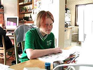 
Sarah Messerer studies at the computer on the dining room table.  She likes biology, and the family made a trip to the Minnesota Zoo to launch her study of marine biology. (MPR Photo/Stephanie Hemphill)