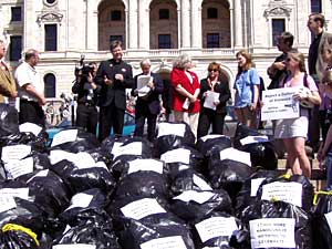 
About 75 people gathered to protest the concealed carry law. The labels on the bags say, "17,000 more guns is nothing to celebrate!" (MPR Photo/Tom Scheck)
