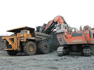 
A shovel dumps taconite rock into a mining truck. The rock will be driven to the mine's "crusher" building, where it will be pulverized into gravel sized chunks, and eventually processed into taconite pellets.  (MPR Photo/Bob Kelleher)