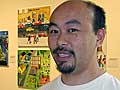 Artist Cy Thao stands next to "The Hmong Migration", his exhibit at the Minneapolis Institute of Arts. (MPR Photo/Laura McCallum)