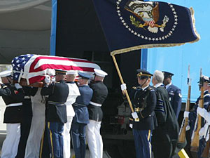 
The flag-draped casket bearing the remains of former  president Ronald Reagan is lifted by a  joint service honor guard to be loaded onto the presidential plane. (ROBYN BECK/AFP/Getty Images)