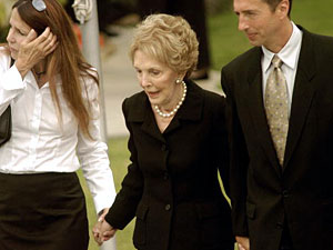 
  Former first lady Nancy Reagan with her daughter Patti Davis (L) and son Ron Reagan walk to their escort vehicle after view the flag-draped coffin of former President Ronald Reagan being placed into an awaiting hearse at the Gates Mortuary. (Photo by Sandy Huffaker/Getty Images)