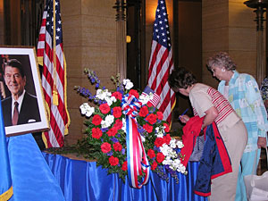
Two people sign a book at a memorial set up at the Minnesota Capitol to honor former President Ronald Reagan (MPR Photo/Laura McCallum)
