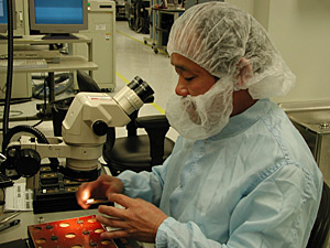 
A technician examines the components of a pacemaker on the manufacturing floor at Guidant's manufacturing campus at Arden Hills. Guidant's factory in Clonmel, Ireland has a similar "clean-room" environment. (Photo courtesy of Guidant Corp.)