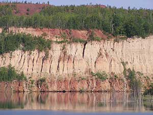 
The walls rise almost straight up, nearly 200 feet above the Canisteo pit.  The retired mine pit looks like something out of the American Southwest.  But it's eroding, and flooding -- putting nearby towns at risk. (MPR Photo/Bob Kelleher)