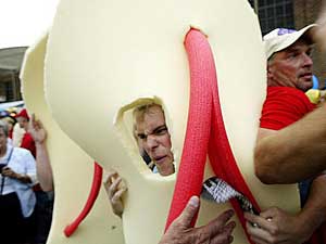 
A demonstrator wearing a flip-flop costume gets angry as he is pushed back by supporters of Democratic presidential candidate John Kerry during a visit to the Minnesota State Fair.  (HECTOR MATA/AFP/Getty Images)