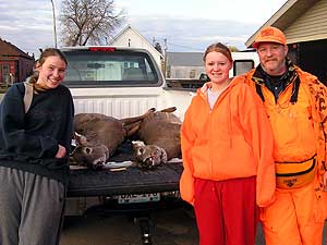 
Tabatha, left, and Heidi Johnson of Mounds View shot two deer Saturday south of Baudette. The girls, pictured with their father, Paul, agreed to allow DNR workers to remove the animals' lymph nodes for CWD testing. DNR officials say most hunters were happy to cooperate. (MPR photo/Tom Robertson)