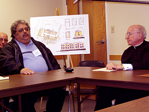 
Catholic Archbishop Harry Flynn listens as St. Paul resident Conrad Pena explains how the Neighborhood Development Alliance helped him find the resources to rehabilitate his home after he lost his job.  
 (MPR Photo/Toni Randolph)
