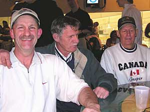 
The tradition of curling in Bemidji goes back generations. In fact, Charlie Schmitt, far right, is hoping to have a four-generation curling team on the ice once his grandchild gets a little older. Also pictured are Schmitt's son, Mike, left, and curler Darrel Bahr. (MPR photo/Tom Robertson)