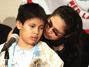 
Survivor Lance Crowe, left, talks to his mother Janet Crowe during the news conference Thursday at the North Country Regional Hospital in Bemidji. (Photo by JEFF HAYNES/AFP/Getty Images)