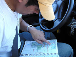 
Aniceto Flores looks at a map to find the house of a potential client.  (MPR Photo/Bianca Vazquez Toness)