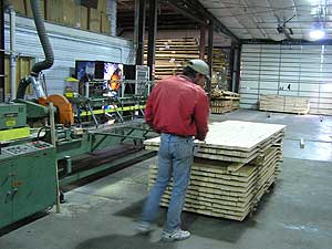 
The machine at left glues short lengths of wood to create long boards.  It enables the Rajalas to produce higher quality boards from lower quality wood. (MPR Photo/Stephanie Hemphill)