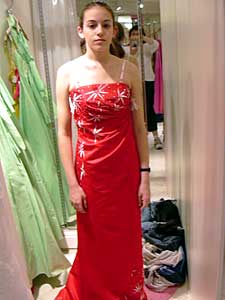 
After an extended discussion, we decided to go with the red dress -- even though it's strapless (her lingerie straps are showing here). But mom will be sewing on some straps before prom night! (MPR Photo/Melanie Sommer)