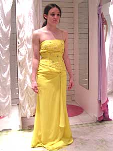 
Carli Cooper tries on a yellow chiffon dress at Glitz. She decides she likes it, but the cost -- $280 -- is more than she and her mother want to spend. (MPR Photo/Bianca Vazquez Toness)