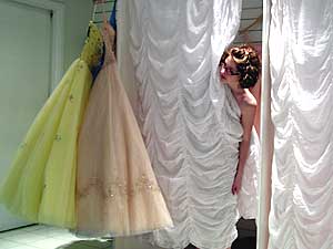 
Chelsea Lawrence, 16, peeks out of the dressing room at Glitz to ask her mother to find another size dress. Lawrence attends St. John's Preparatory School in Collegeville.  
 (MPR Photo/Bianca Vazquez Toness)