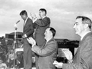 
John F. Kennedy, far left, speaking to group at a Minnesota airport during his 1960 presidential campaign.
Prominent Minnesota Democrats were there with him, including Orville Freeman, to the right of Kennedy, Hubert Humphrey, and McCarthy, far right.  (Photo by Duff Johnston, courtesy of the Minnesota Historical Society)