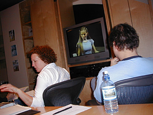 
Producer Anne Swarts, left, and art director Karl Madcharo view one of the many applicants for "woman on scooter." (MPR Photo/Jeff Horwich)