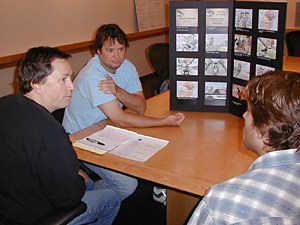 
Kerker copywriter Terry Thomas, left, first spotted Whiplash as a part of a rodeo in the Twin Cities. He and art director Karl Madcharo, center, explain the plot of the newest spots to creative director and Kerker executive V.P. Chris Preston. (MPR Photo/Jeff Horwich)