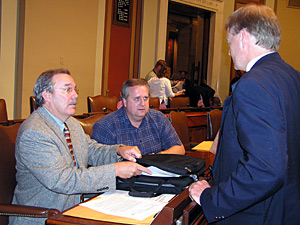 
Rep. Dennis Ozment and Rep. Al Juhnke talk to Rep. Mark Olson after the House floor session on Thursday. Ozment and Juhnke are among a group of legislators trying to reach budget accords without legislative leaders. (MPR Photo/Laura McCallum)